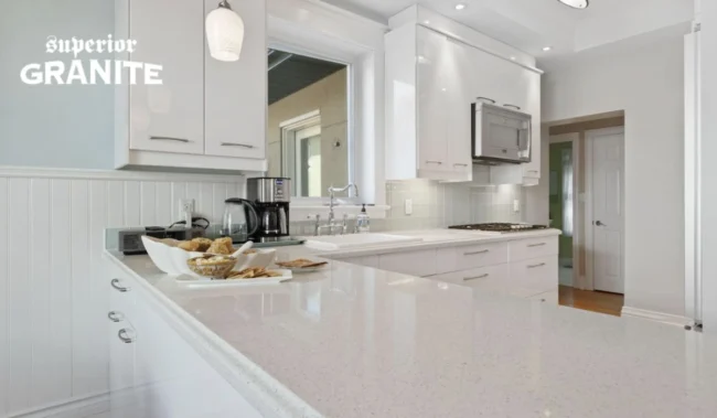 White granite kitchen countertops in a modern kitchen with white cabinets, subway tile backsplash, and built-in appliances. White granite kitchen countertops in a modern kitchen with white cabinets, subway tile backsplash, and built-in appliances.