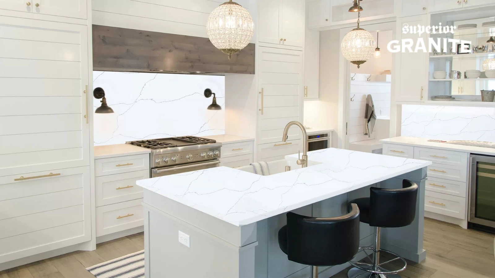 Modern white kitchen with a large island and matching backsplash, highlighting various quartz countertop colors that perfectly complement the sleek cabinetry.