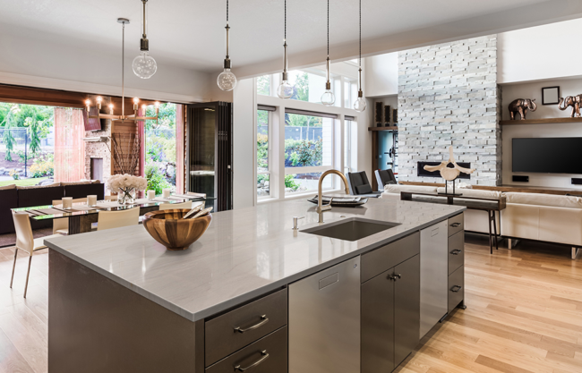 A modern white kitchen with a large granite island and wooden stools, showcasing current Kitchen Countertop Trends in Florida. A modern white kitchen with a large granite island and wooden stools, showcasing current Kitchen Countertop Trends in Florida.