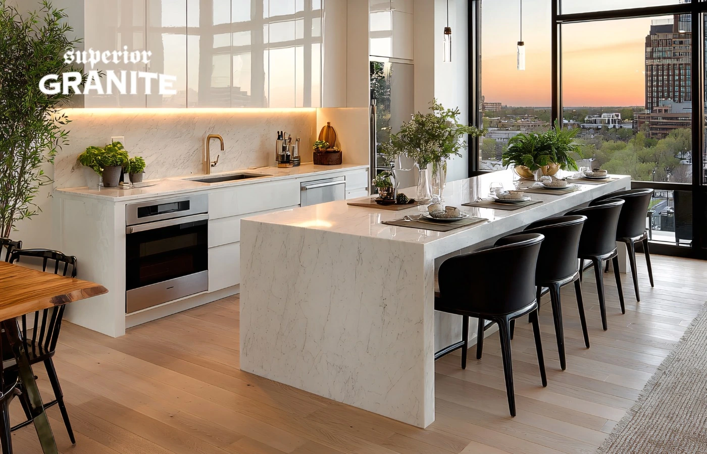 Modern kitchen featuring a white waterfall countertop island with black chairs and a city view.