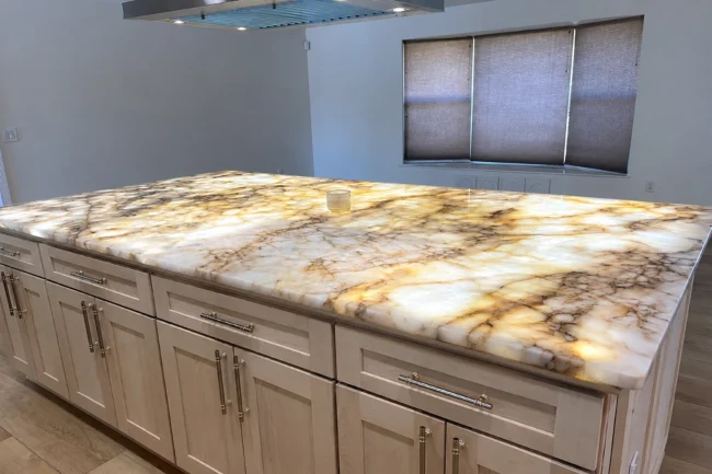 Glowing translucent onyx island featuring modern backlit stone countertops design. Glowing translucent onyx island featuring modern backlit stone countertops design.