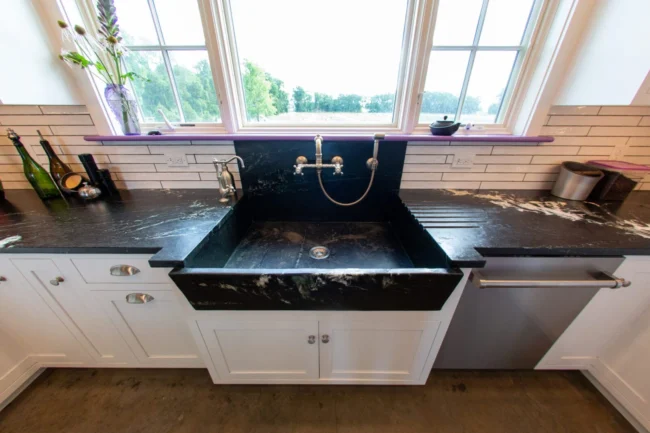 Black marble farmhouse kitchen basin integrated into custom stone sinks setup. Black marble farmhouse kitchen basin integrated into custom stone sinks setup.