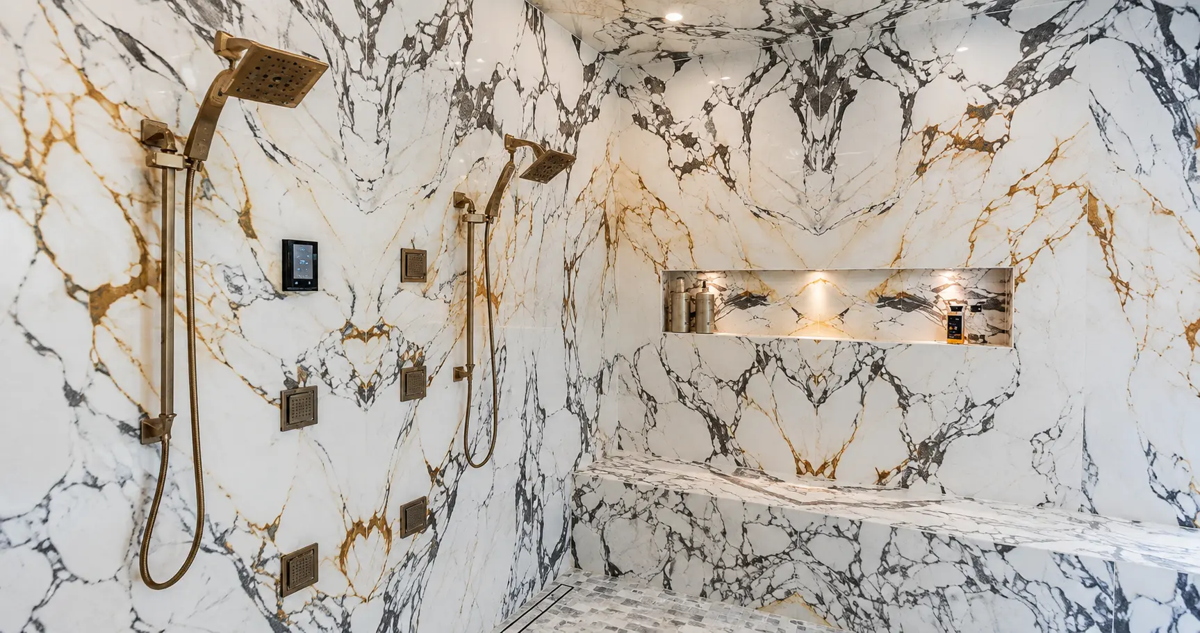 Marble-look large slab walk-in enclosure with gold fixtures: Porcelain Custom Showers.