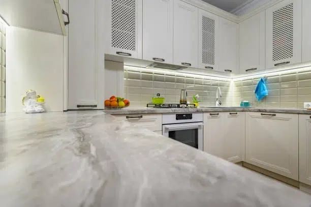 Modern kitchen with Eased Edge on Quartzite Countertops and white cabinets.
