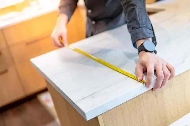 Contractor measuring stone slab: How Long Does Countertop Installation Take guide.