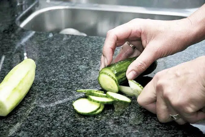 Slicing fresh cucumber directly on dark granite counter: Do You Need to Seal Quartz?