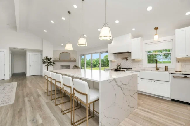 Modern white kitchen with veined waterfall island featuring dolomite countertops.
