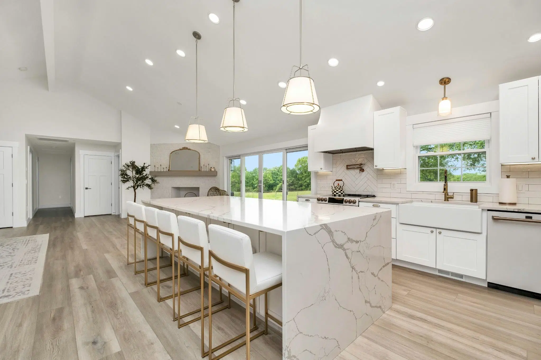 Modern white kitchen with veined waterfall island featuring dolomite countertops.