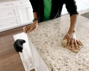 Person wiping stone surface for Does Your Countertop Need Resealing.