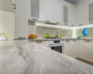 Modern kitchen with Eased Edge on Quartzite Countertops and white cabinets.