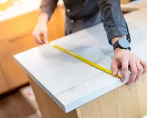 Contractor measuring stone slab: How Long Does Countertop Installation Take guide.