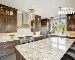 A modern kitchen featuring high-quality Granite Countertops for Kitchens & Bathrooms by Superior Granite, paired with dark wood cabinetry and a large marble-patterned island.