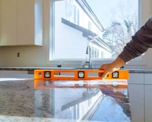 Contractor checking leveling during a granite countertop installation.