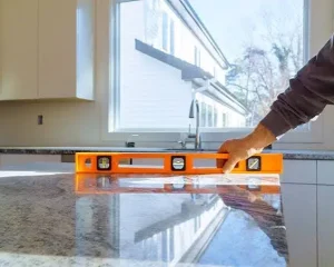 Contractor checking leveling during a granite countertop installation.