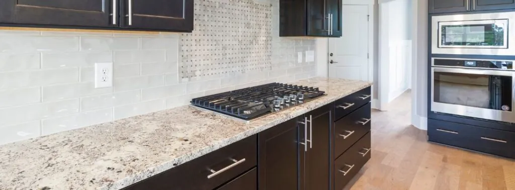 Earthy Granite Countertops With Black Cabinets in a Dramatic Upscale Kitchen