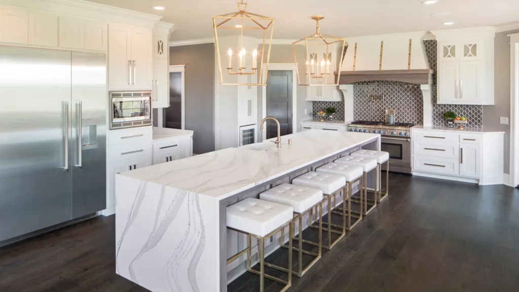 Modern kitchen with large island featuring quartz Waterfall Countertops and bar stools.