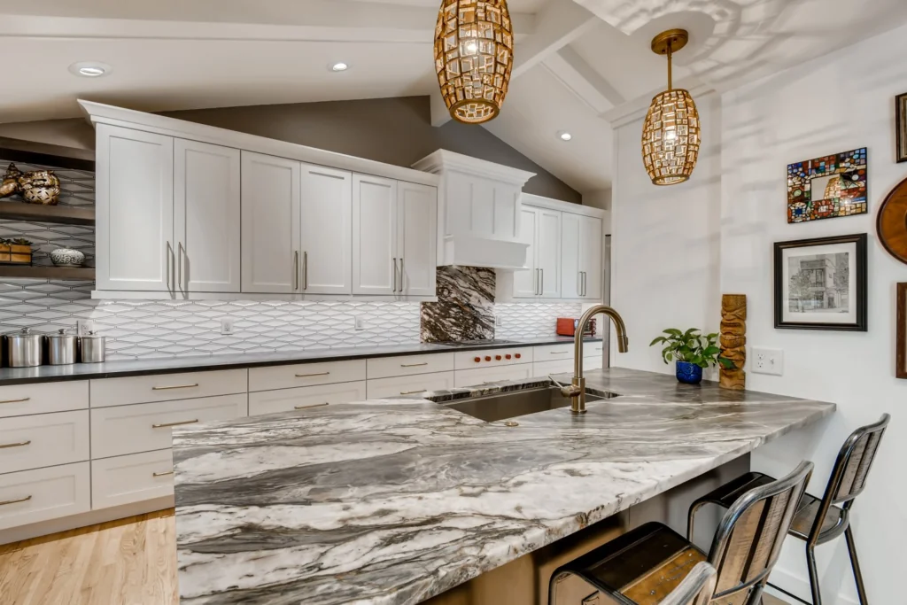 Dramatic dark marbled island in Engineered vs Natural Stone kitchen.