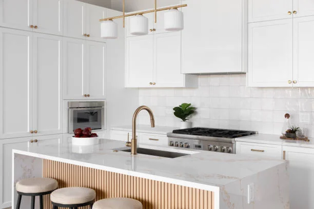 White kitchen island with fluted wood details and marble Waterfall Countertops.