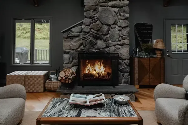 Rustic stacked stone hearth with burning fire showcasing a classic Stone Fireplace.