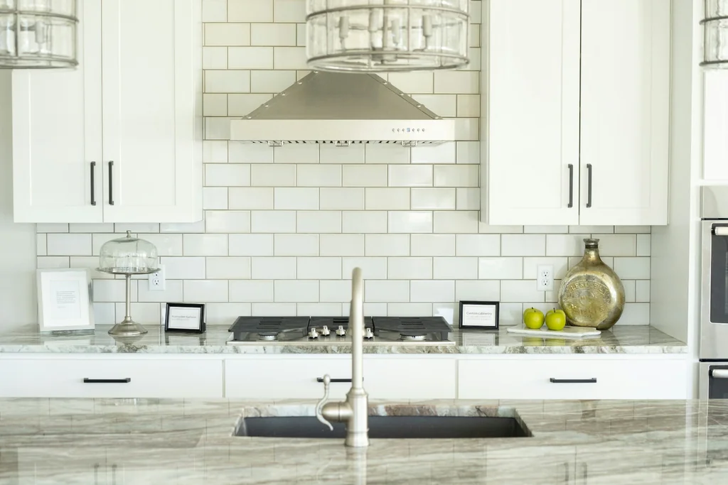Kitchen sink island and cooktop featuring veined Natural Stone Countertops.